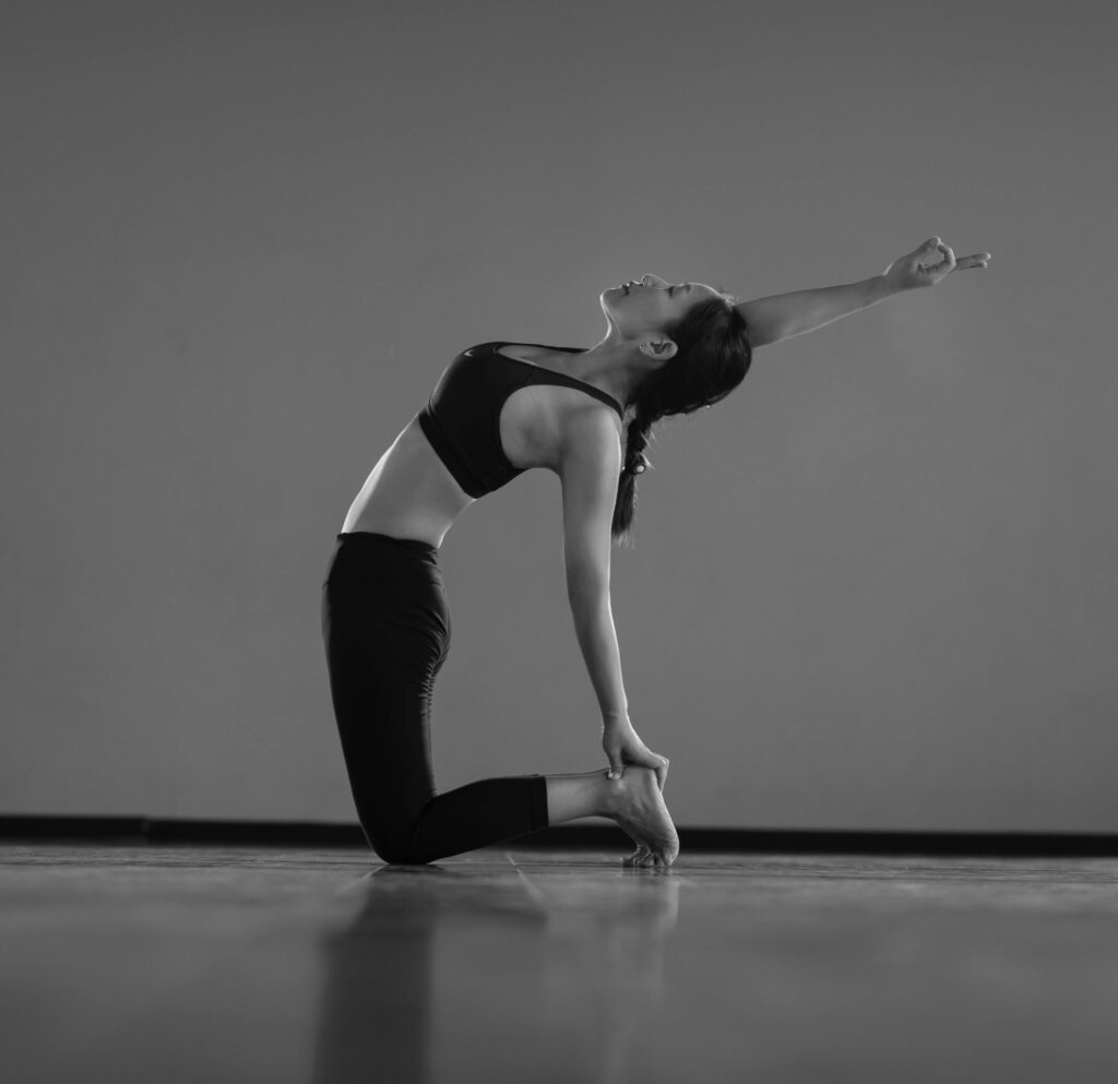 pexels-photo-13849063-13849063 A woman gracefully performing a yoga pose indoors, showcasing balance and flexibility.
